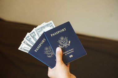 Amerikan pasaportuna sıkıştırılmış Amerikan doları para ve seyahatin birleşiminden oluşan ilginç bir kompozisyon oluşturuyor..