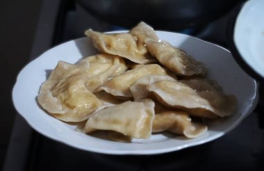 Hamur köftesi yapmak, hamuru sarmak ve içini doldurmak. Ev mutfağında geleneksel yemek pişirme etkinliği.