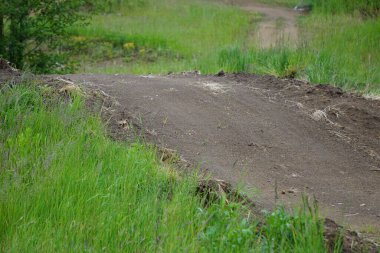 Numara ve atlayış yapmak için tasarlanmış geniş MTB yolu. Yol, rampaları ve dağ bisikleti becerileri için engelleri olan pürüzsüz toprak yüzeyden oluşuyor..