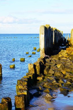 Panoramic view of the Baltic Sea, rough waters, waves hitting the shore, Polish coastline, seaside vacation, natural landscape, dramatic sky, and coastal nature.