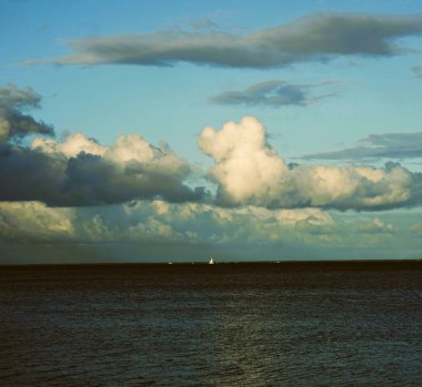 Calm waters of the Baltic Sea captured in a wide shot. The sea surface glistens in daylight, creating a minimalist and relaxing view.