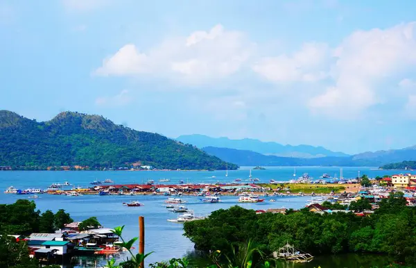 Filipinler 'in Coron şehrinde tekneleri ve gemileri, deniz kenarında evleri ve güzel güneşli havası olan bir turist kasabası..