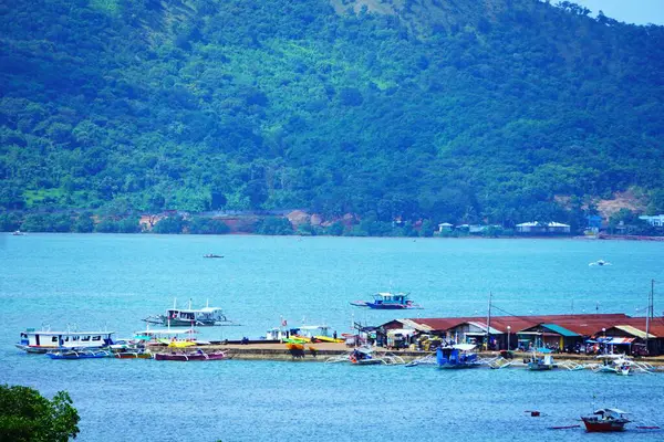 Birçok geleneksel bangka teknesi, Coron yakınlarındaki Palawan 'daki turkuaz suların üzerindeki stilt evlerin yakınına yanaştı..