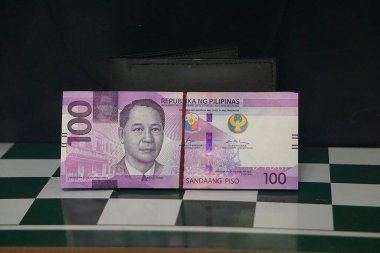 Filipin 100 pesosu klasik tarzda, görünür seri numarası yok, biraz yıpranmış, nötr arka plan.