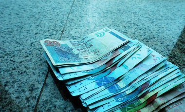 Hong Kong dolar banknotları pencere eşiğine saçılmış, 20 dolarlık banknotun net bir görüntüsü var. Doğal ışık para biriminin dokusunu ve renklerini vurgular.
