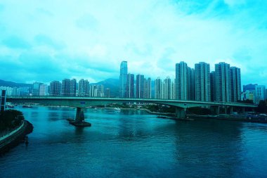 Merkezinde devasa gökdelenler ve körfezi geçen bir köprüyle Hong Kong 'un geniş manzarası. Gökyüzünden metropolün muhteşem manzarası..