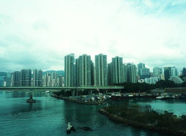 Hong Kong 'un panoramik çekimlerinde arka planda bir köprü ve modern gökdelenler var. Etkileyici bir altyapının ve dinamik şehir siluetinin birleşimi.