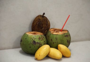 Tarafsız bir zeminde bir marang, hindistan cevizi ve birkaç mango. Doğal, tropik bir ortamda egzotik meyveler..