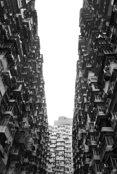 Hong Kong 'daki ikonik Canavar Binası' nın siyah beyaz fotoğrafı. Kontrastlı ışık ve derinlik kentsel yoğunluğun dramatik bir etkisini yaratır.