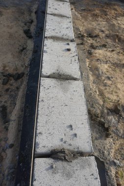 Cement blocks on pallets at a construction site, ready for building a house, organized materials, foundations and walls, realistic construction site view, construction work, construction crew.