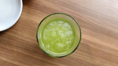 Japon yeşil çayının ya da Ocha çayının ya da uzun bardakta servis edilen sarı içkinin üst görüntüsü. Ryokucha Japon çayı ahşap masada.