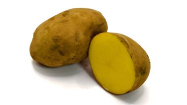 Bir tane taze patates ve bir tane de kesilmiş patates, beyaz arka planda izole edilmiş.