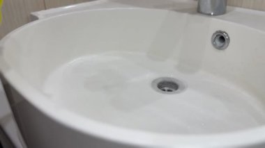 Kireç pulu sünger ve eldiven kullanarak lavabodan çıkarılıyor.