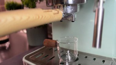 Ev portafinter makinesiyle espresso yapıyorum. İskele filtresi yerleştiriliyor, kahve akıyor ve krema sonunda sorunsuz bir şekilde yerleşiyor. Sıcak bir ev kahvesi sahnesi..