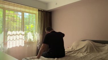 Yatak odasındaki bir adam yastık ve şilteye vurarak yoğun duygularını dışa vurur. Sahne, stresi, hayal kırıklığını ve özel bir mekandaki duygusal patlamayı resmediyor..