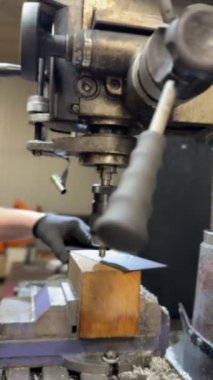 Endüstriyel matkap makinesi metal plakalarda delikler açıyor. Fabrika ortamında hassas mekanik işlemler. Metal iş ve üretim kavramı.