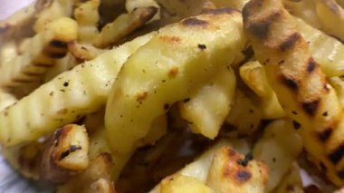 Evde tavada pişen sıcak patates kızartmasının makro videosunu kapat. Baharatlı ve doğal buhar efektli çıtır altın patatesler, ev yapımı yemekleri ayrıntılı olarak gösteriyor..