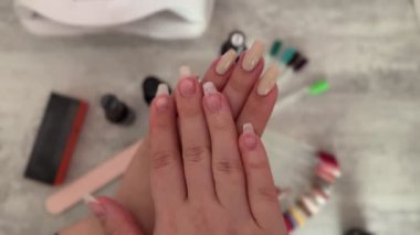 Genç bir kadın ellerinin karşılaştırmasını gösteriyor, biri taze jöle cilalı ve diğeri doğal. Güzellik endüstrisi konsepti ve tırnak bakımı.