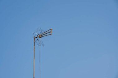 Arkaplanda açık mavi gökyüzü olan UHV anten veya televizyon anteni