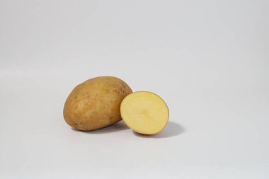 Taze taze patates ve yarım. Beyaz arka planda izole edilmiş patatesler. Patatesleri sökün. Hasat koleksiyonu. organik, taze kazılmış patatesler. Sebzeler. dilimler.