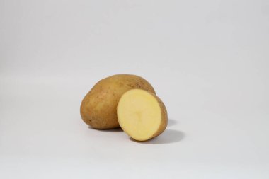 Taze taze patates ve yarım. Beyaz arka planda izole edilmiş patatesler. Patatesleri sökün. Hasat koleksiyonu. organik, taze kazılmış patatesler. Sebzeler. dilimler.