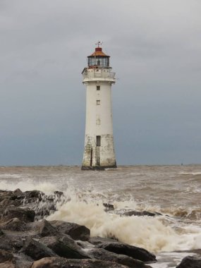 Bu resimde, Perch Rock Feneri olarak da bilinen tarihi New Brighton Deniz Feneri, elementlere karşı dirençli olarak ayakta duruyor.. 