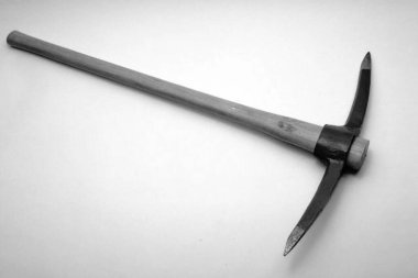 Uzun tahta saplı ve çift uçlu metal başlı bir kazma.