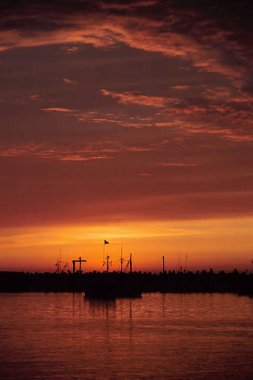 Gemi Siluetleriyle Sahilde Dramatik Günbatımının gerçekçi bir görüntüsü