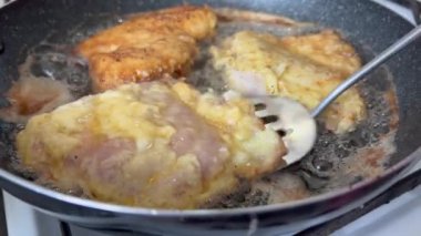 Altın hamuru yapmak. Tavada et kızartmak ve spatula kullanmak. Yemek pişirme konsepti. Tavada yağlı tavuk bifteği pişirmek. Yemek yap. Ev yapımı tavuk kızartması..