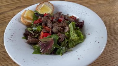 Green salad with meat on white plate. Fresh vegetable salad with beef. lunch time.