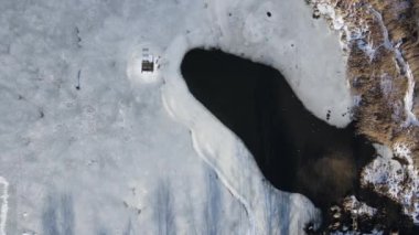 Frozen lake, snowy. Top down drone shot.