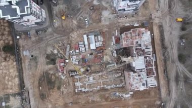 Yukarıdan düşen İHA, yüksek katlı bir konut binasının yeni inşaatının görüntüsünü verdi. Konut inşaatı. 