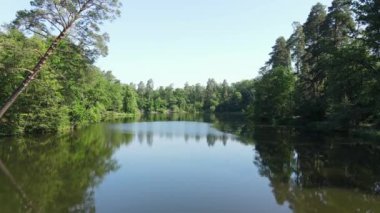 İHA 'da vuruldu. Su yüzeyinde pürüzsüz bir uçuş. Orman bölgesi. Güzel manzara. Yeşil bir ormanın ortasında sakin bir göl.. 