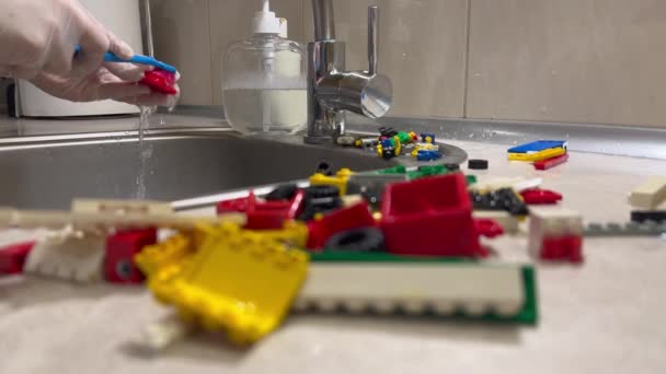 歯ブラシクリーンなカラフルなプラスチックコンストラクターブロックと女性の手 カラフルなコンストラクタブロックを洗浄します 子供用コンストラクタブロックキューブ おもちゃを洗う — ストック動画