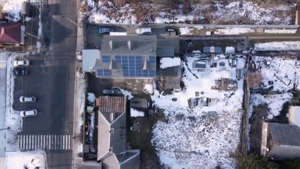 村の家の屋根の上に太陽光発電所 冬の時間どこでも雪が — ストック動画