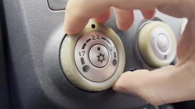 Kafkas erkek elinin sıcaklığı kontrol düğmesini çevirmesine yaklaş