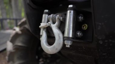 ATV Vinç Kancası 'nın yakın çekimi. ATV vinç kancası çelik bir kabloyla, sağlam metal dokusunu ve dayanıklı tasarımını yakalıyor. Bir off-road macerası ve güvenilirlik sembolü.