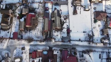 İnsansız hava aracı güneş panelleri ve kış zamanlayıcısı olan evlerin çatısına yakın çekim yaptı. Kar battaniyeleri çatılar, yollar ve bahçeler. Geleneksel evler dar sokaklar. 