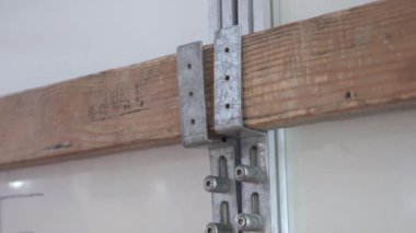 Geçici kapı kapama: ahşap kiriş metal parantez ve kılavuz raylarla korunur. Tadilat veya inşaat aşamalarında kullanılır..