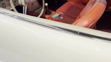 İçinde deri koltuklar, retro gösterge paneli ve manuel vites vardiyası olan klasik bir araba.. 