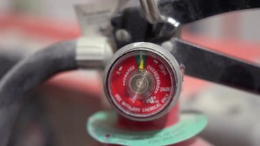 Operasyon durumunu gösteren yangın söndürücü basınç göstergesinin detaylı görüntüsü. İnşaat veya teknik alanda kapalı alanda yakalanmış.. 