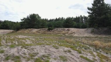 İnsansız hava aracı, ender bulunan çimenlerle kumlu bir düzlüğün üzerinde alçaktan uçar ve sonra yoğun bir çam ormanını ortaya çıkarmak için yükselir. Yerden ağaca düzgün geçiş sinematik perspektif sağlar.