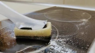 Mutfakta süngerle elektrikli soba temizliyorum. Temizlik, hijyen ve ev bakımı.. 