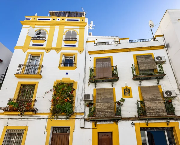 stock image Yellow and white building with beautiful balconies in the historic center of Seville, Andalusia, Spain