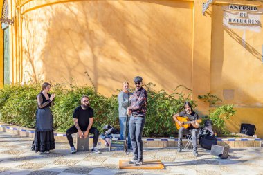 Seville, İspanya - 11 Mart 2023: Flamenko dansçısı Turistler için sokakta bir tablaya dokunuyor