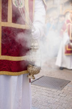 Censer being shaking by a altar boy or acolyte in the holy week procession to produce smoke and fragrance of incense