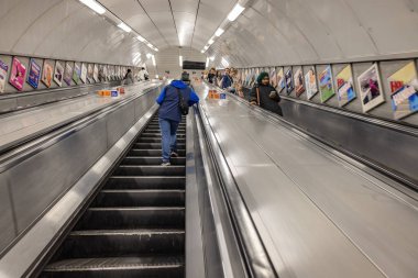 Londra, İngiltere - 20 Mayıs 2023: Yeraltı metrosunda yürüyen merdivenlerin uzun pozlu fotoğrafları