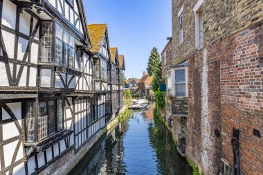 Canterbury yakınlarındaki Stour nehrinin su kanalı, nehirde turist botu geziyor. Canterbury, Kent, İngiltere ve İngiltere 'deki Stour nehrine bakan tipik binalar.