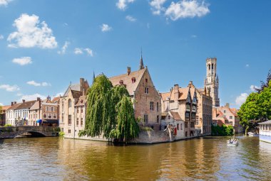 The Quay of the Rosary (Rozenhoedkaai) canal in Bruges with the classic medieval buildings and the Belfry Tower of Bruges in the background, Belgium clipart