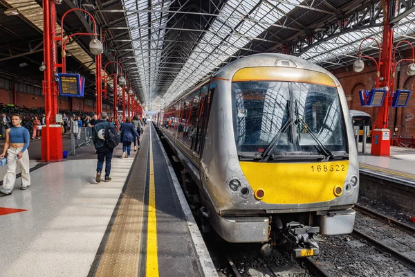 Londra, İngiltere - 18 Mayıs 2023: Tren istasyonundan ayrılmak üzere olan bir banliyö treni